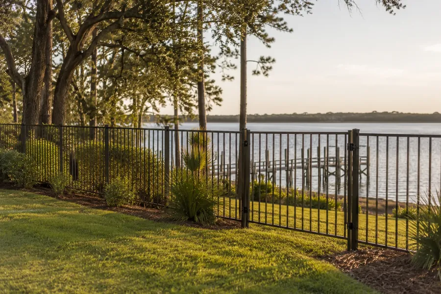 Black powder-coated aluminum ornamental fence near the water